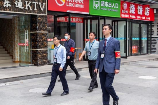 图为陈吉(右一)巡查生活区。 受访者供图