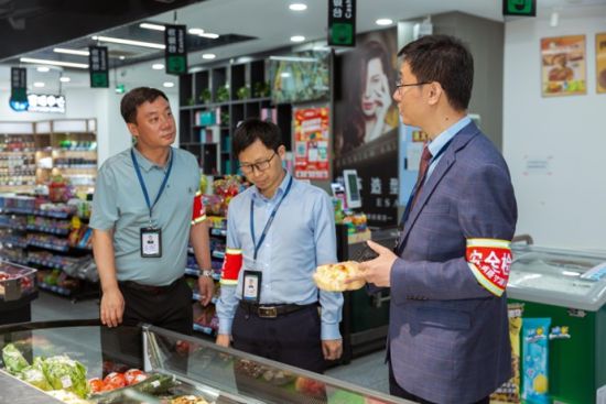 图为陈吉(右一)进行食品安全检查。 受访者供图